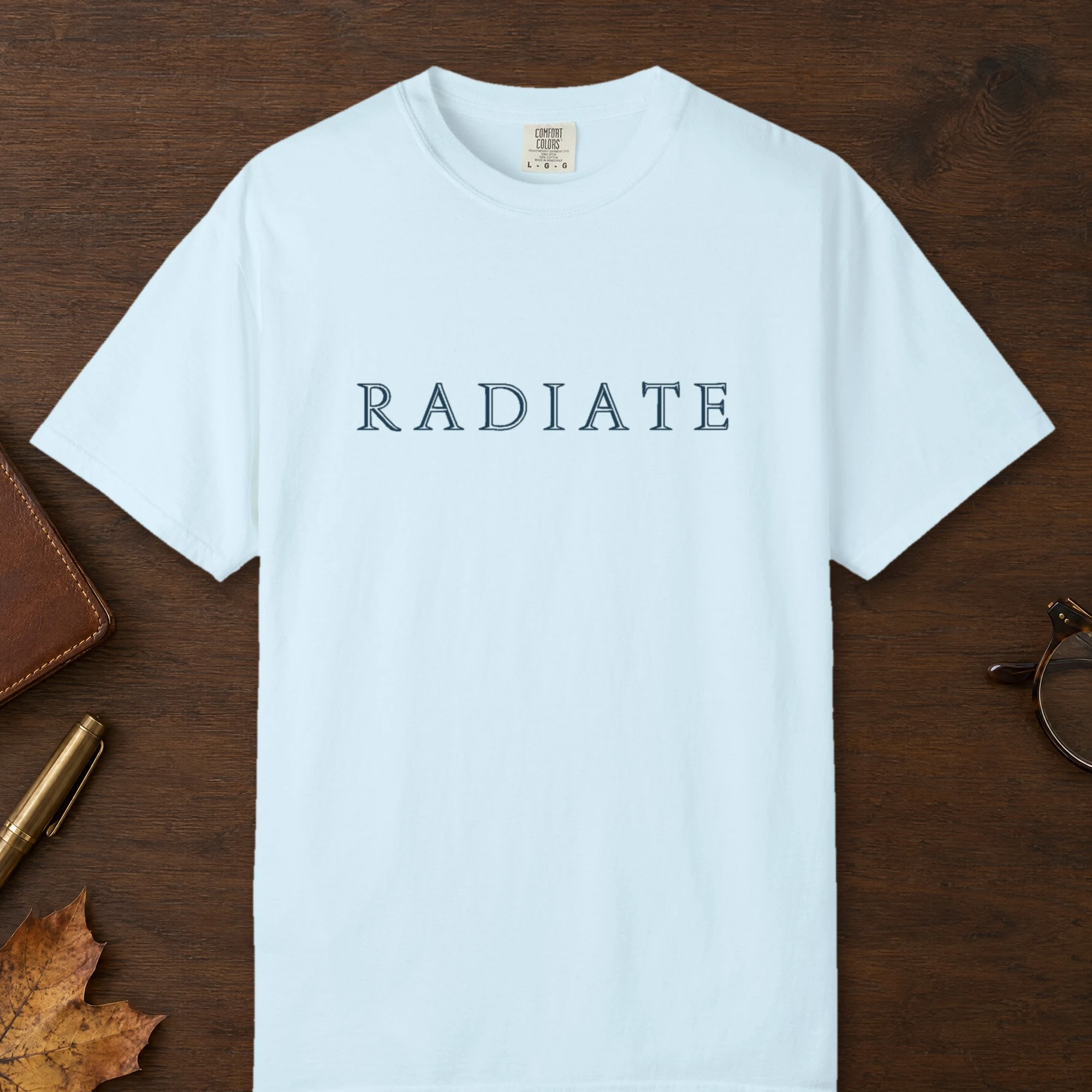 Radiate Inline Capitals design on a Chambray Comfort Colors 1717 tee, laid flat