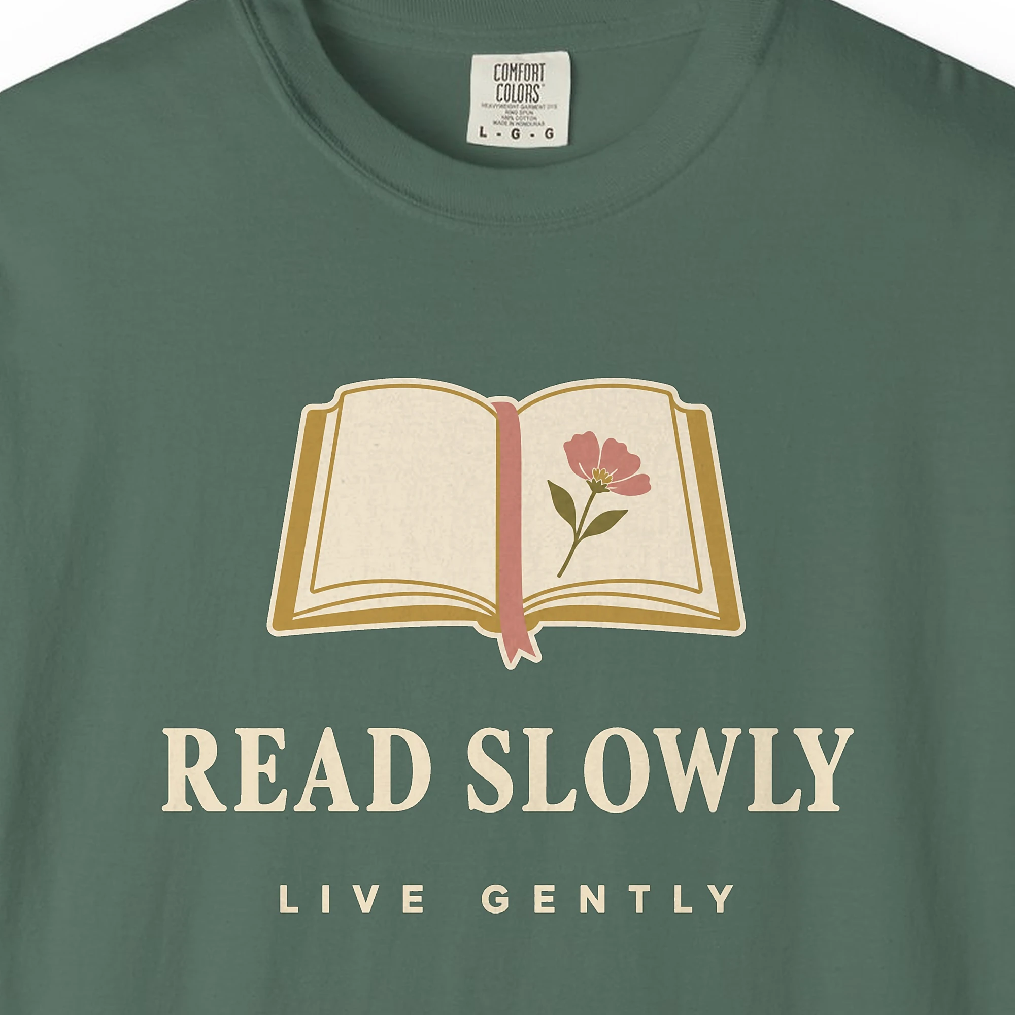 read-slowly-live-gently-tee-blue-spruce-chest Close-up of the Read Slowly Live Gently print on a Blue Spruce Comfort Colors 1717 tee