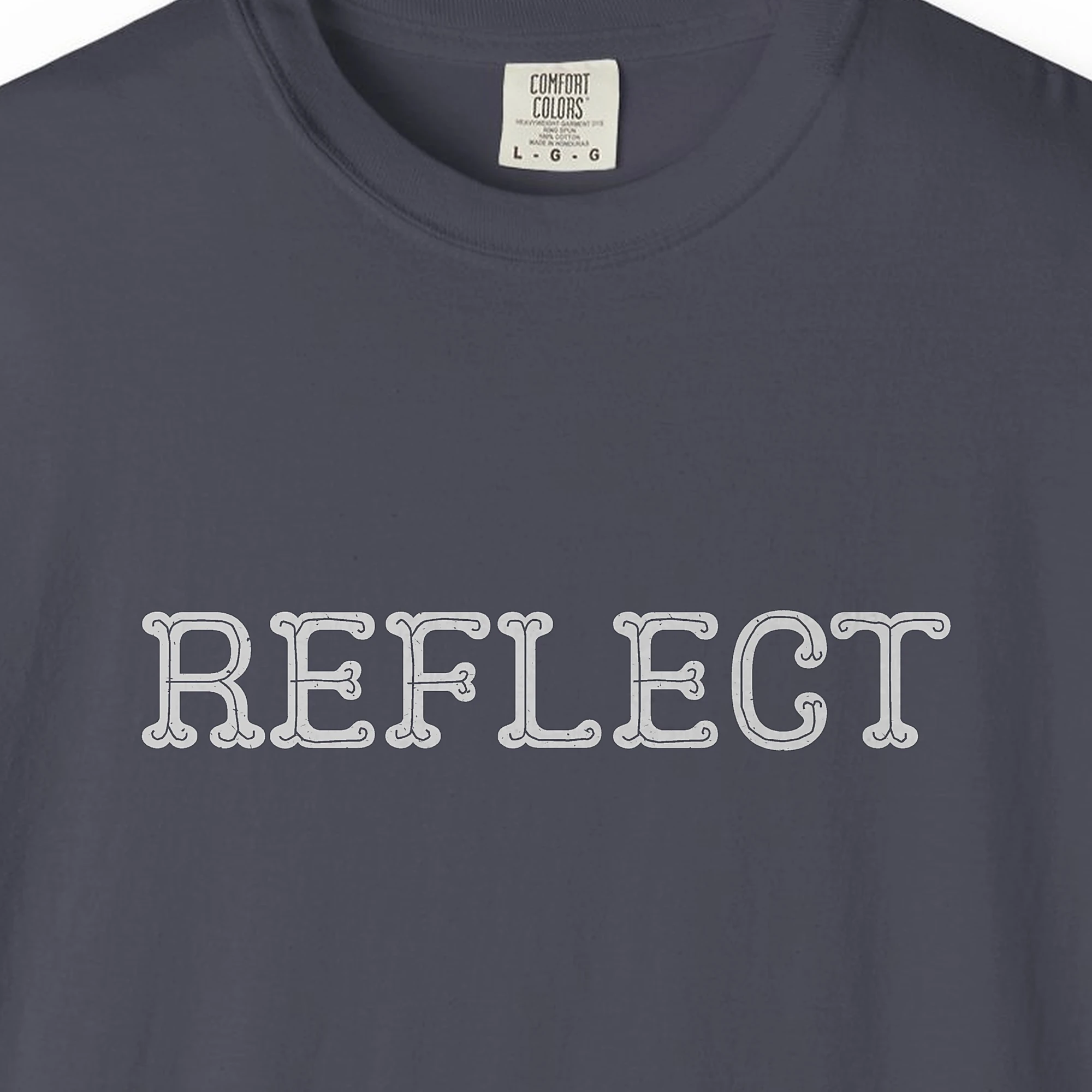 Close-up of the Reflect print on a Navy Comfort Colors 1717 tee