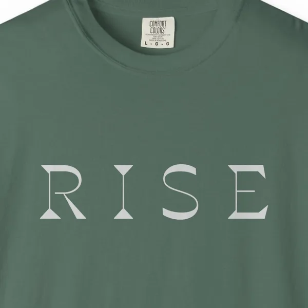 rise-bold-capitals-tee-blue-spruce-chest Close-up of the Rise Bold Capitals print on a Blue Spruce Comfort Colors 1717 tee
