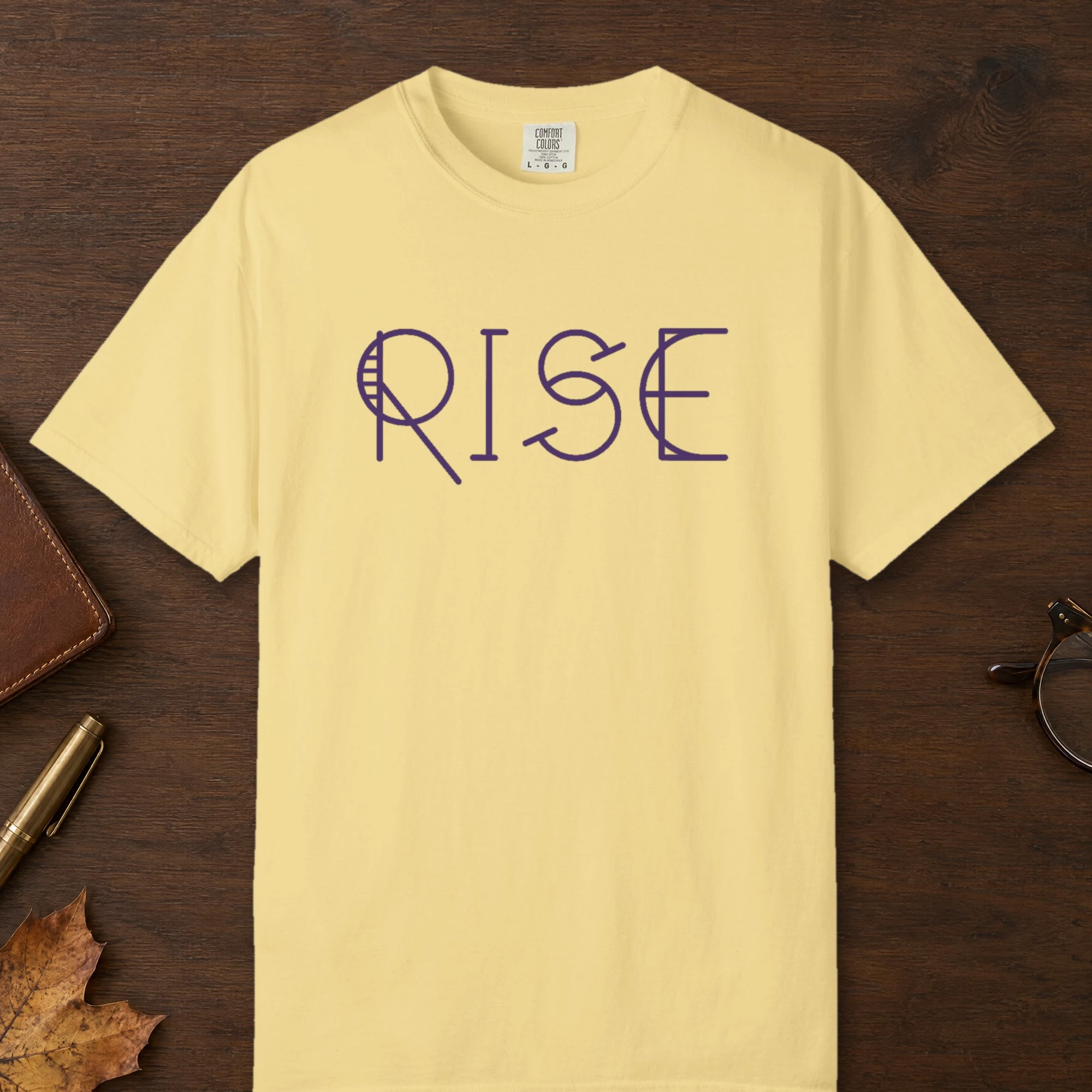 Rise design on a Butter Comfort Colors 1717 tee, laid flat