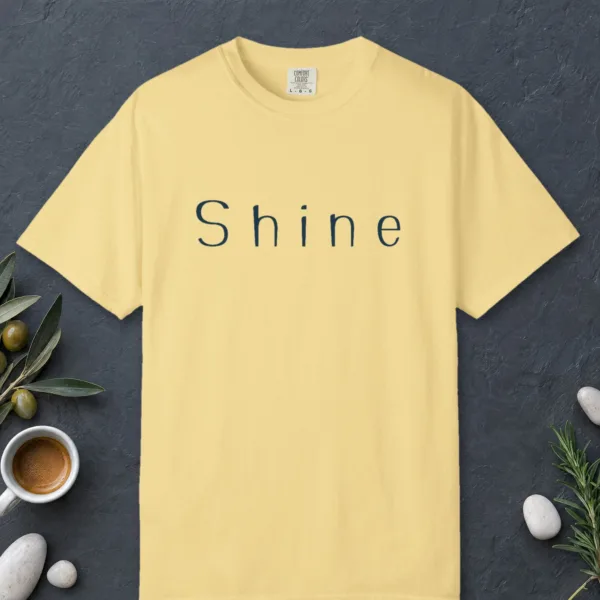 shine-wide-letter-tee-butter-front Shine Wide Letter design on a Butter Comfort Colors 1717 tee, laid flat