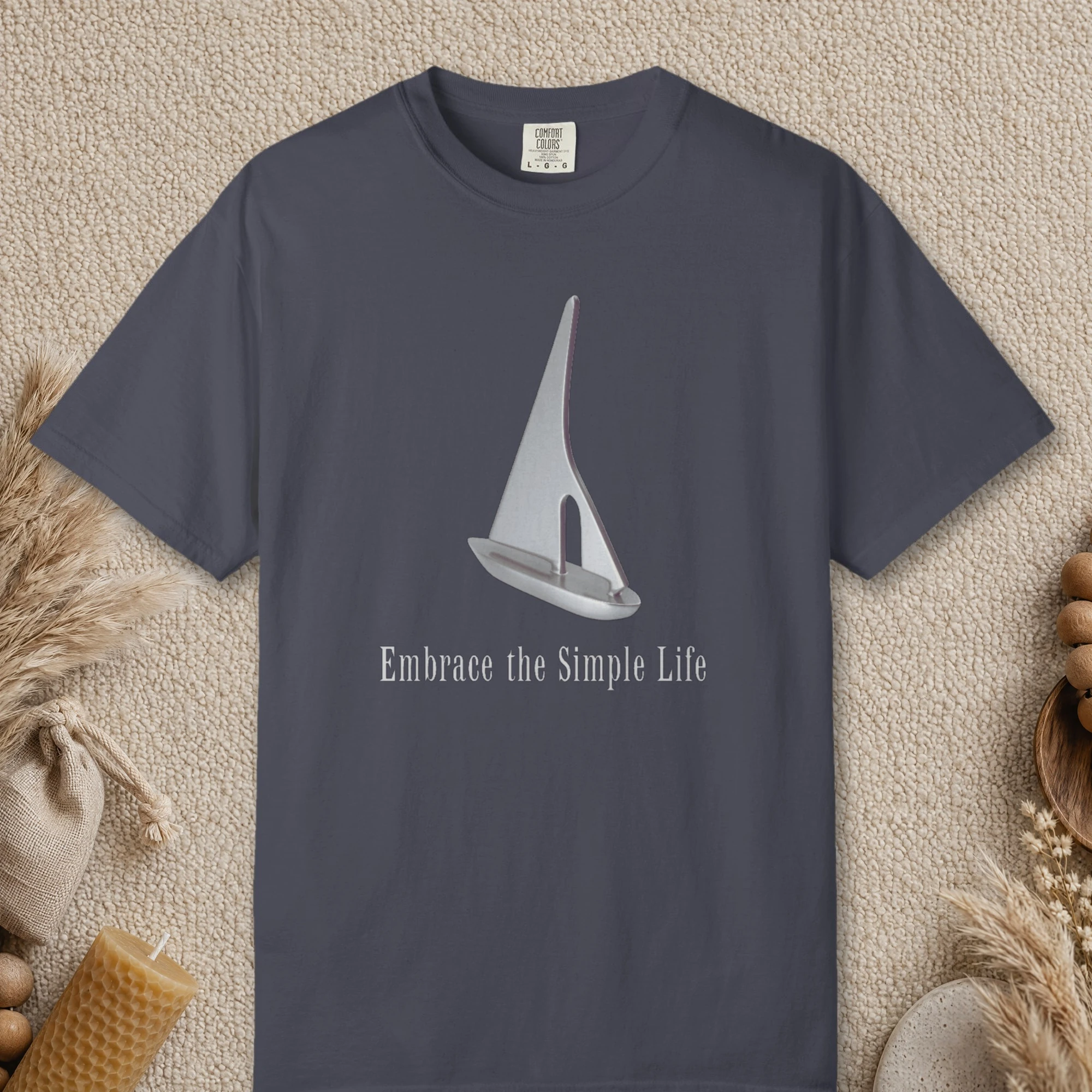 Silver Sailboat design on a Navy Comfort Colors 1717 tee, laid flat