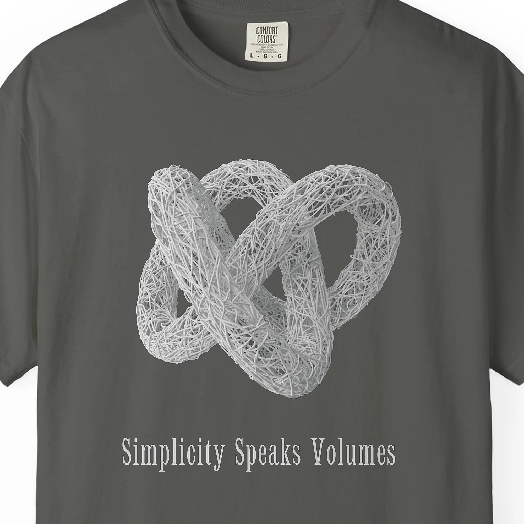 simplicity-speaks-volumes-tee-pepper-chest Close-up of the Simplicity Speaks Volumes print on a Pepper Comfort Colors 1717 tee