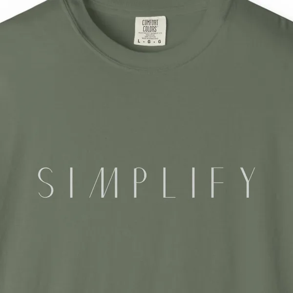 Close-up of the Simplify Spaced Capitals print on a Moss Comfort Colors 1717 tee