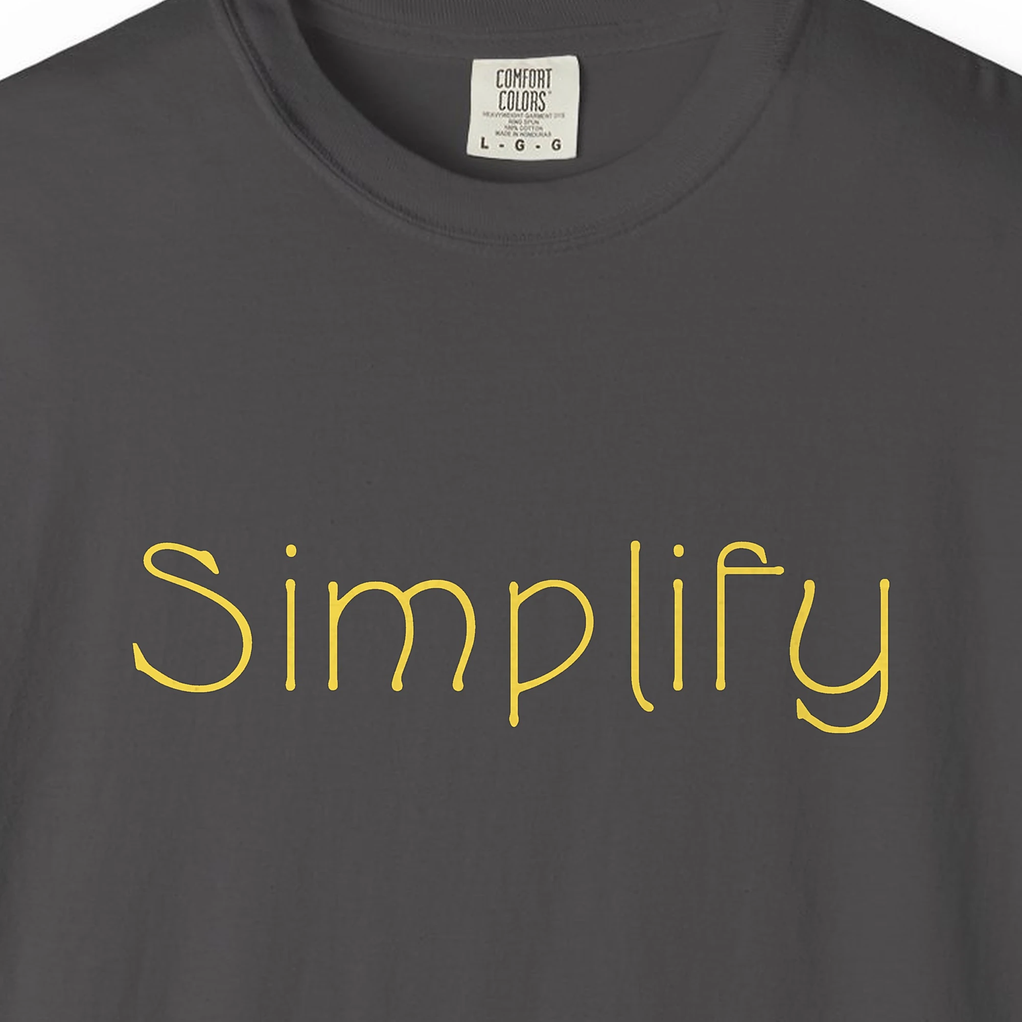 Close-up of the Simplify print on a Graphite Comfort Colors 1717 tee