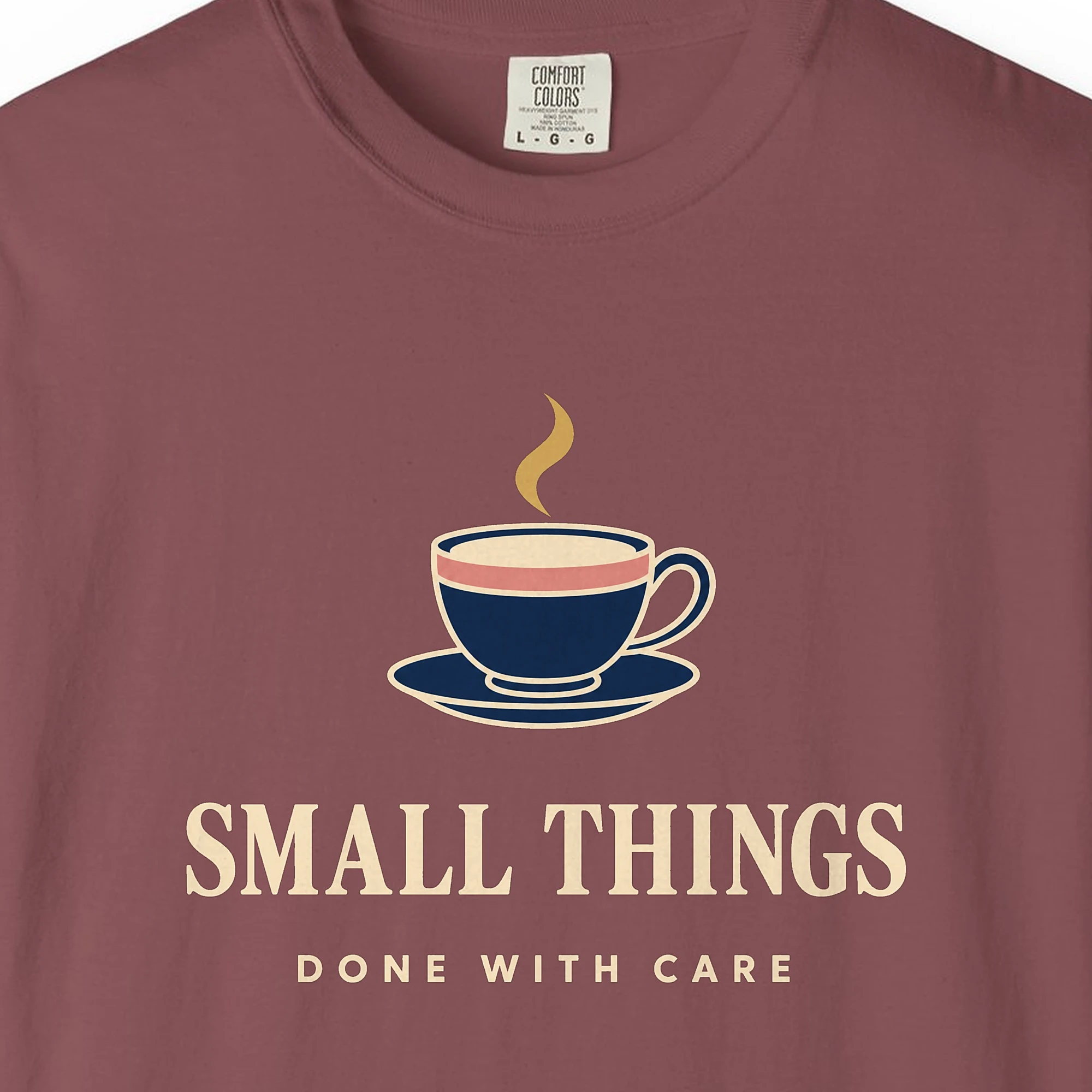 Close-up of the Small Things Done with Care print on a Brick Comfort Colors 1717 tee