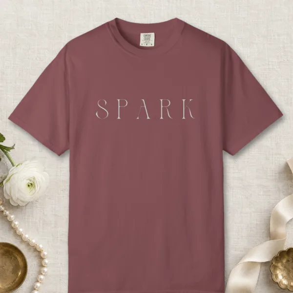 Spark Fine Capitals design on a Brick Comfort Colors 1717 tee, laid flat