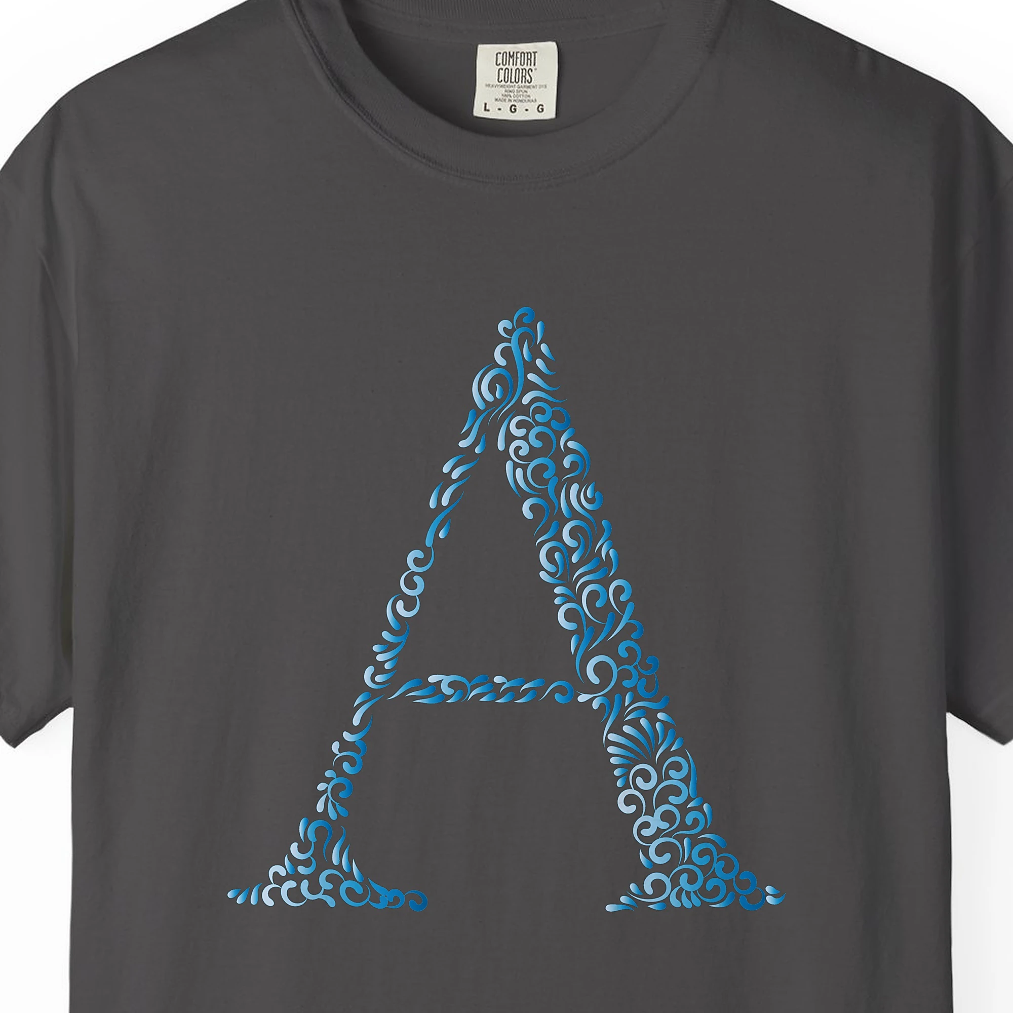 Close-up of the Swirling Letter A print on a Graphite Comfort Colors 1717 tee