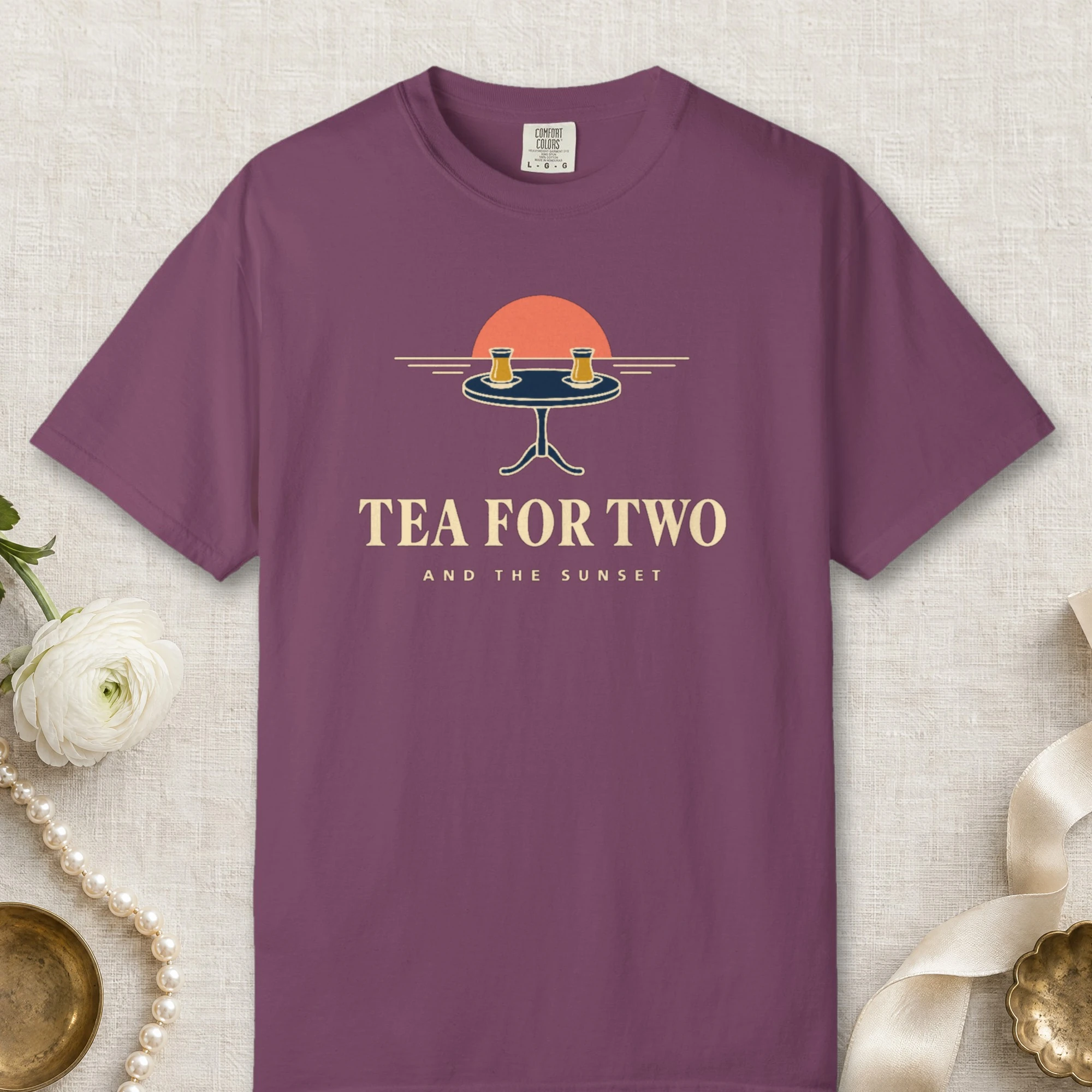 Tea for Two and the Sunset design on a Berry Comfort Colors 1717 tee, laid flat