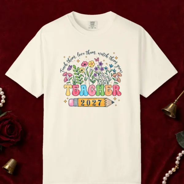 Teach Them Love Them design on a Ivory Comfort Colors 1717 tee, laid flat