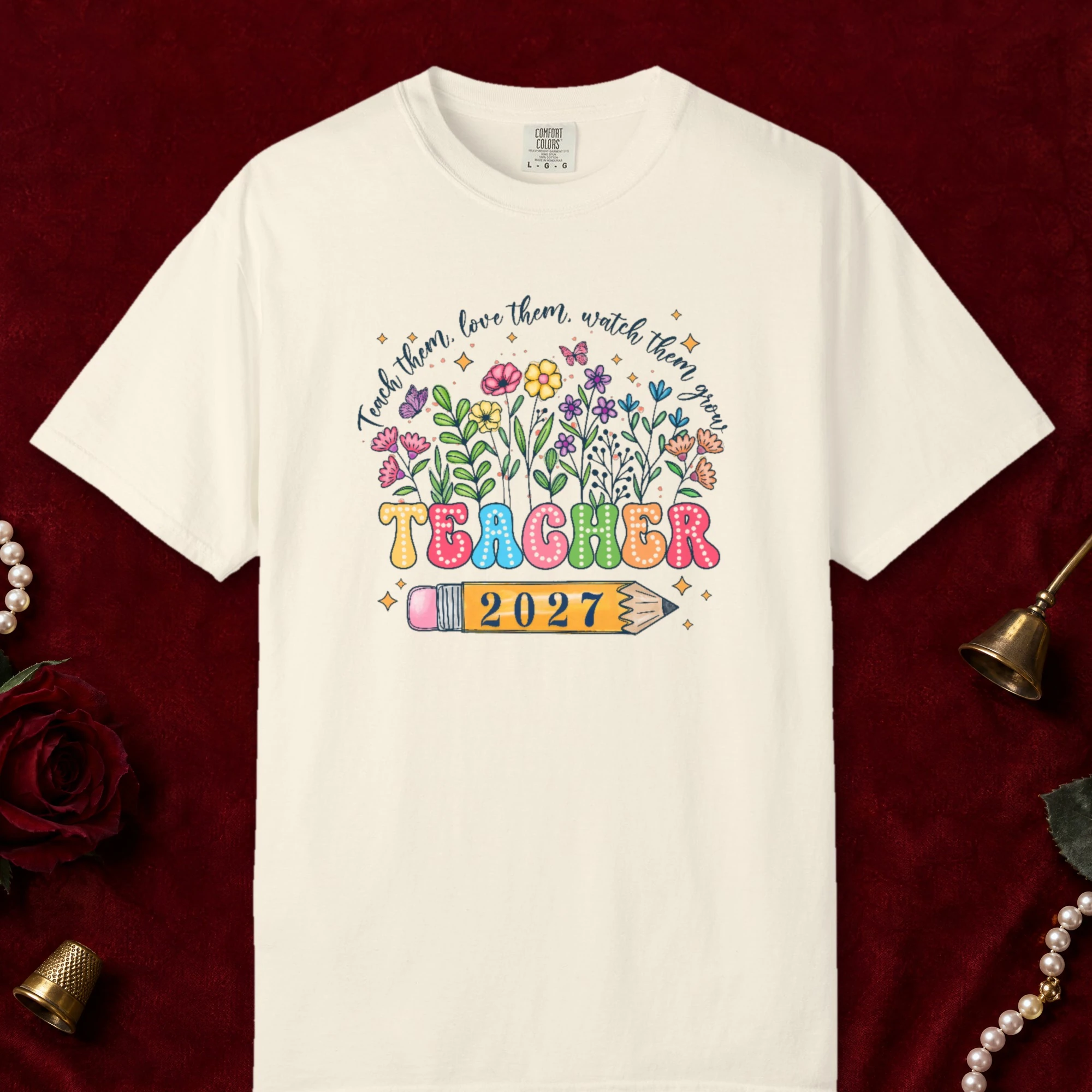 Teach Them Love Them design on a Ivory Comfort Colors 1717 tee, laid flat