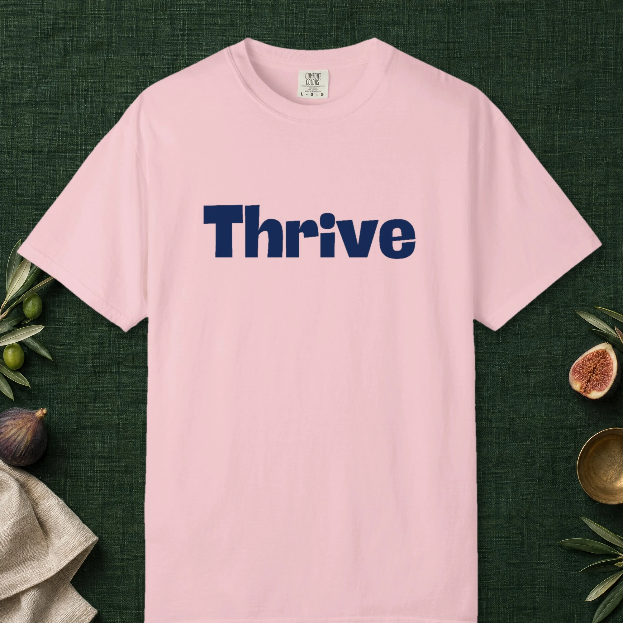 Thrive design on a Blossom Comfort Colors 1717 tee, laid flat