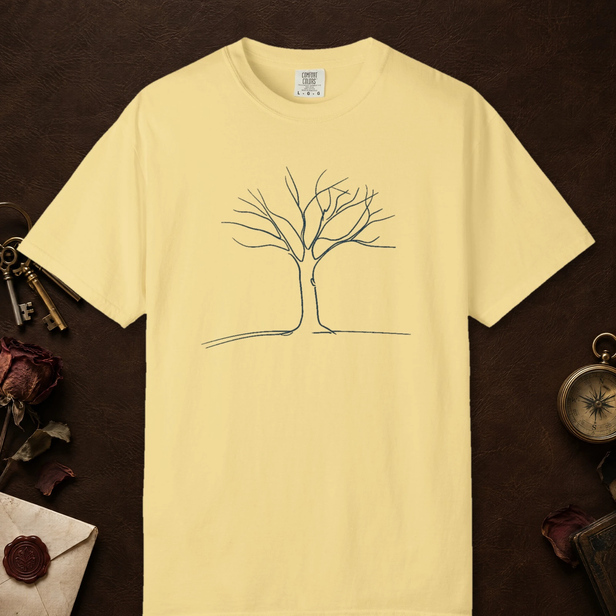 Tree on a Quiet Hill design on a Butter Comfort Colors 1717 tee, laid flat