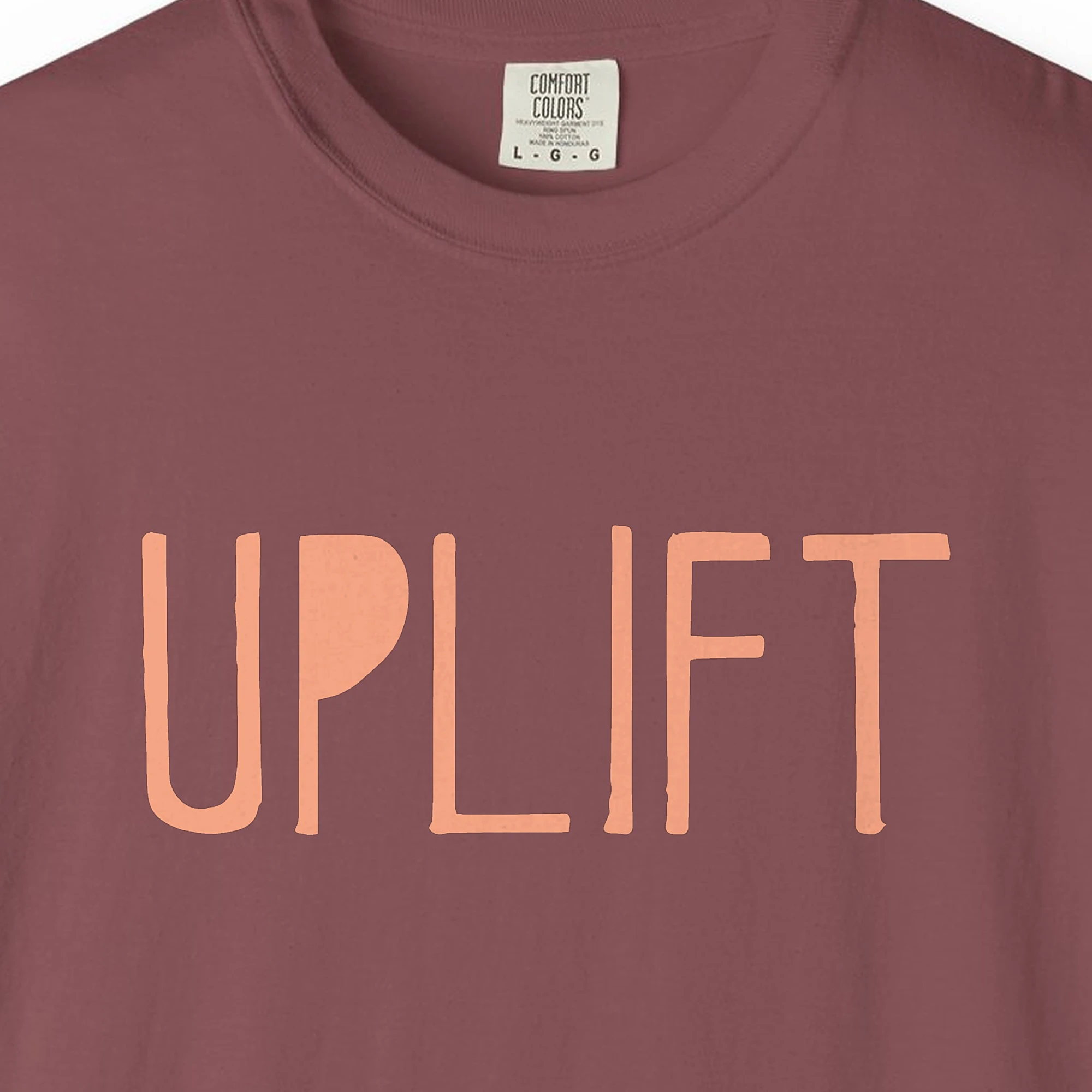 Close-up of the Uplift print on a Brick Comfort Colors 1717 tee