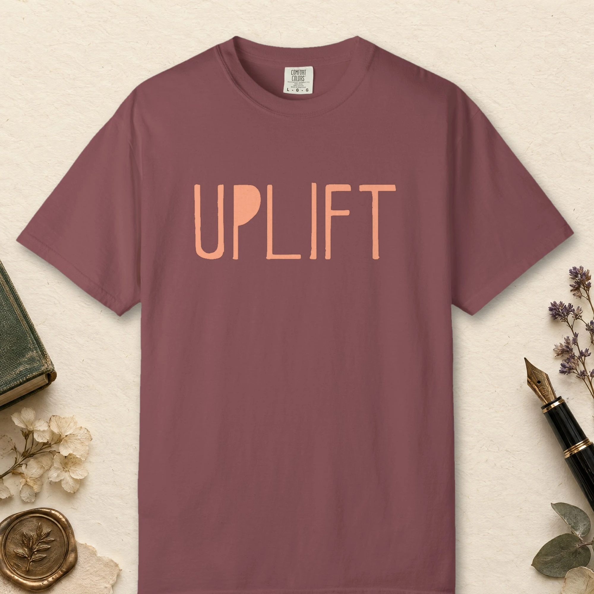Uplift design on a Brick Comfort Colors 1717 tee, laid flat