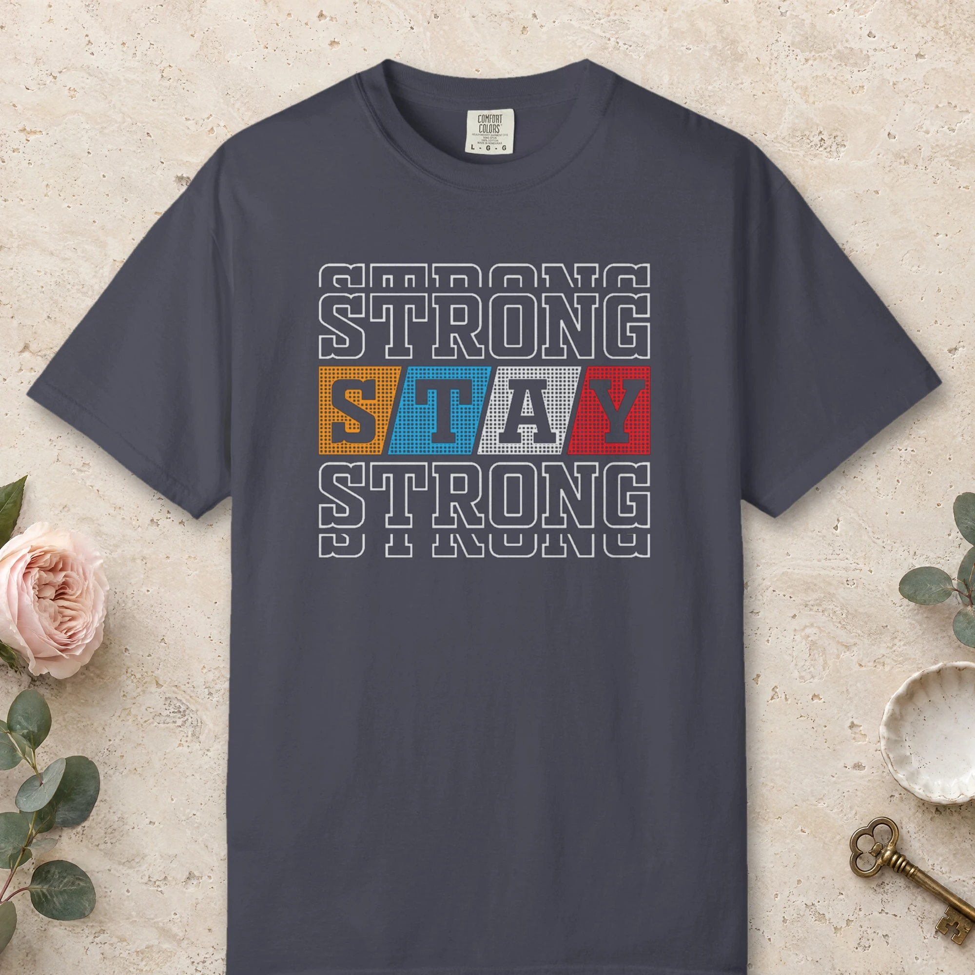 Varsity Strength design on a Navy Comfort Colors 1717 tee, laid flat