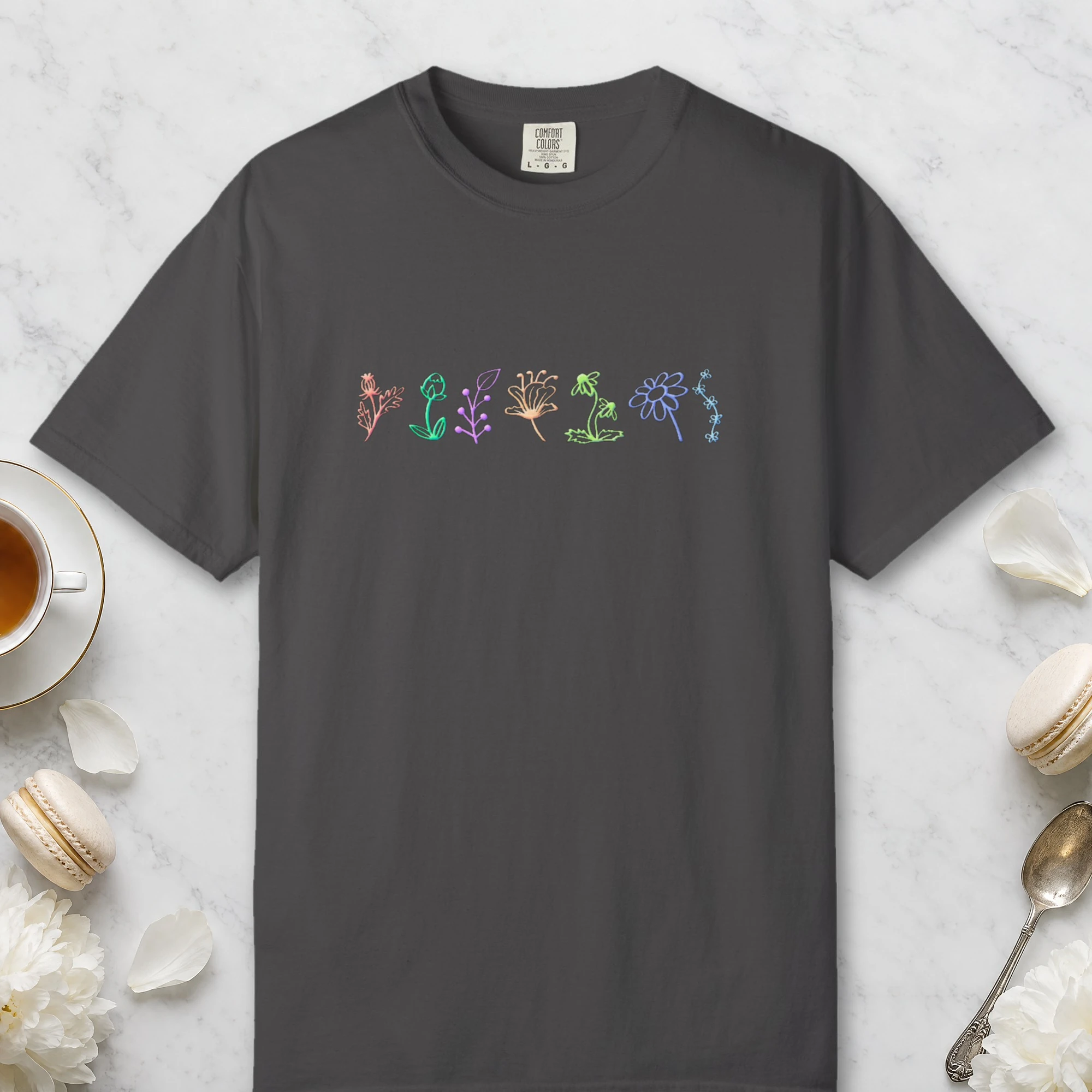 Wildflower Row design on a Graphite Comfort Colors 1717 tee, laid flat